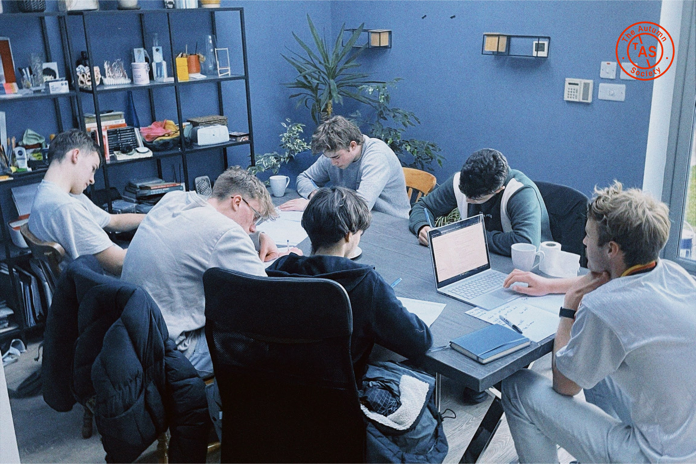 Image of people working in a group with The Autumn Society logo in the top right